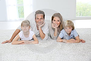 Happy family lying on carpet at home