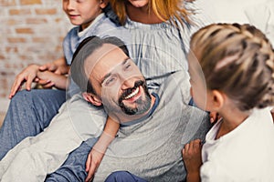 Happy family lying down on bed at home