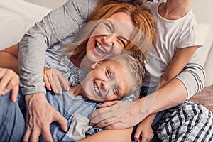 Happy family lying down on bed at home