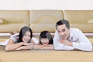 Happy family lying on the floor near the sofa