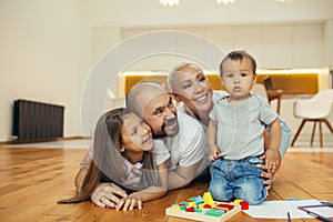 Happy family lying on floor in new countryhouse