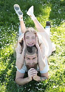 Happy family lying on flowery meadow. Bearded man and his pretty brunette daughter on picnic in countryside. Lovely