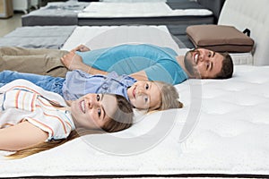 Happy family lying on new orthopedic mattress
