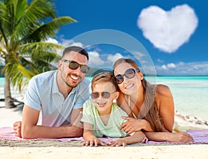 happy family lying over tropical beach background