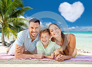 happy family lying over tropical beach background