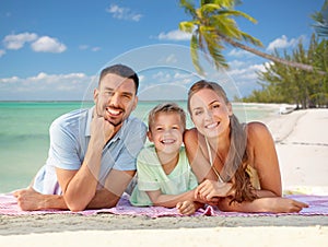 happy family lying over tropical beach background