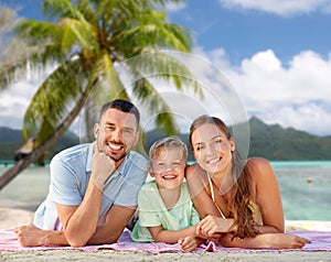 happy family lying over tropical beach background