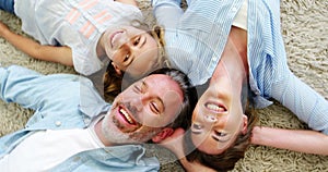 Happy family in lying on rug in living room