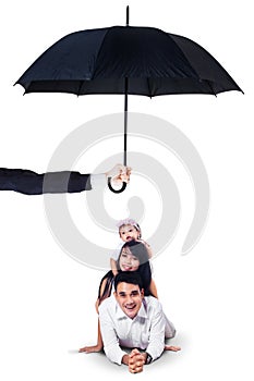 Happy family lying in studio under umbrella