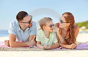 Happy family lying on summer beach