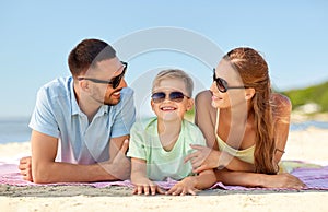 Happy family lying on summer beach