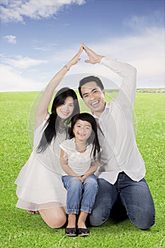 Happy family making hand made house on a meadow