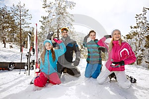 Family making snow balls on skiing in mountain