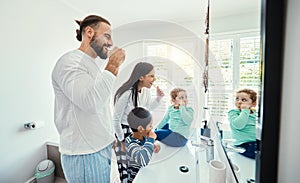 Happy family, man and kids in bathroom for brushing teeth, healthcare and bonding to start morning in house. Young