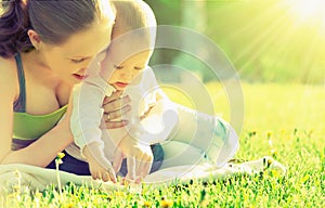 Happy family. Mom and baby in a meadow in the summer in the park