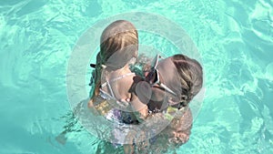 Happy family, mom and child have fun in the summer in the swimming pool