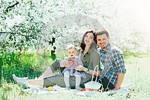 Happy family mom dad and baby daughter having fun outdoor in park smiling and laughing. Lifestyle Emotions Relationship Love