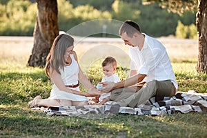 Happy family mom dad and baby son happy in nature spending time together on summer sunny day. The concept of a fun holiday