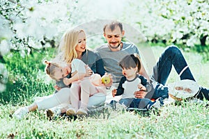 Happy family mom dad and kids daughter and son having fun outdoor in park smiling and laughing. Lifestyle Emotions Relationship