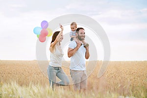 Happy family of mom, dad and son walking outdoors