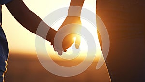 happy family. mom and daughter hold hands close up. mother and baby girl hands together at sunset. parent girl and child