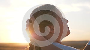 A happy family. Mom and daughter are walking in the park at sunset. Baby and mom admire the beautiful sunset in the