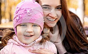 Happy family mom and little girl playing outdoors in autumn park. Little girl and her mother in the autumn park. soft focus