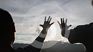 Happy family mom and son in field at sunset. Mom with son stretches out her hand in the sun. faith in god dream a religion concept