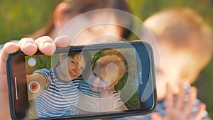 Happy family mom and son take selfie using smartphone. The family smiles, has fun, takes photos and communicates online