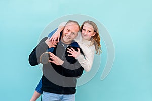 Happy family moments. Father holds laughing happy daughter piggyback.