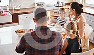 Happy family, morning and breakfast on kitchen table for meal, eating or bonding time together at home. Mother, father