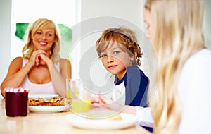 Happy family, morning and breakfast on weekend, portrait and eating for nutrition, orange juice and meal. Mother