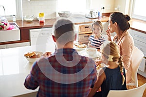 Happy family, morning and eating breakfast on kitchen for meal or bonding time together at home. Mother, father and