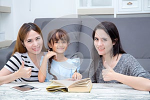 Happy family mother, aunt, freind and daughter teaching read a b