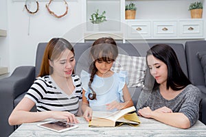 happy family mother, aunt, freind and daughter teaching read a book.