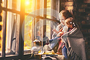 Happy family mother and baby in autumn window