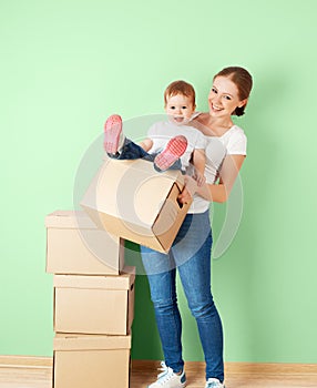 Happy family mother and baby daughter in an empty apartment with