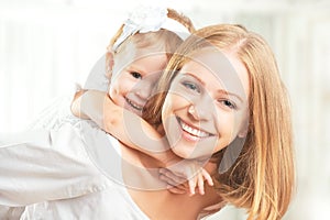 Happy family: mother and baby daughter hugging and laughing