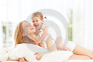 Happy family mother and baby daughter playing and laughing baby