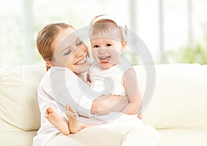 Happy family. Mother and baby daughter plays, hugging, kissing