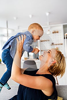 Happy family. Mother and baby daughter plays, hugging, kissing at home