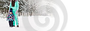 Banner happy family mother and baby girl daughter playing and laughing in winter outdoors in snow copy space