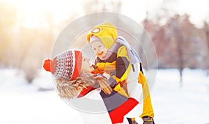 Happy family mother and baby is happy snow on winter walk