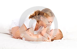 Šťastná rodina matka a dieťa zabávajúci sa usmievavý na posteľ 
