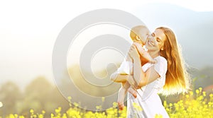happy family mother and baby hugging and kiss in summer on nature
