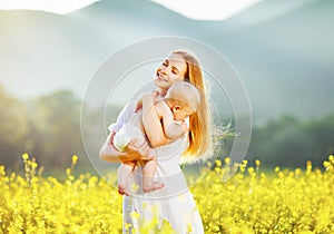 Happy family mother and baby hugging nature in summer