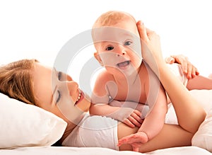 Happy family. Mother and baby lie and embrace in the bed