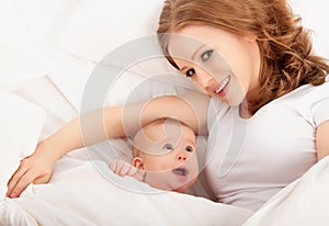 Happy family. Mother and baby lie and embrace under blanket