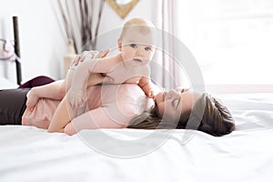 Happy family. Mother and baby playing and smiling under a blanket