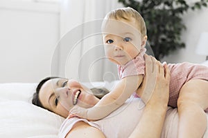 happy family. Mother and baby playing and smiling under a blanket